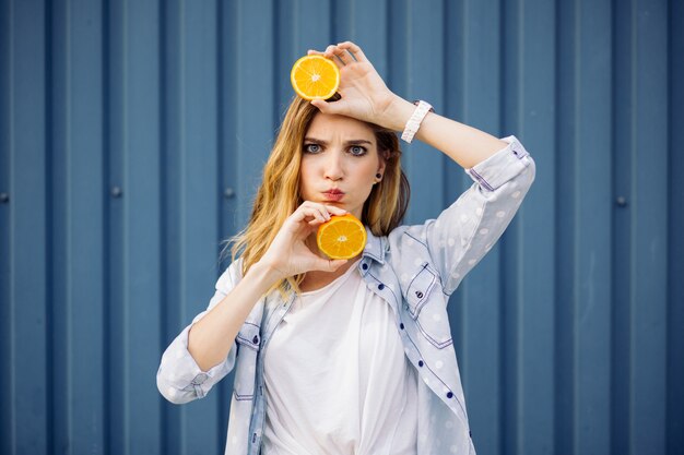 Femme souriante, tenue, deux, orange, dans, mains