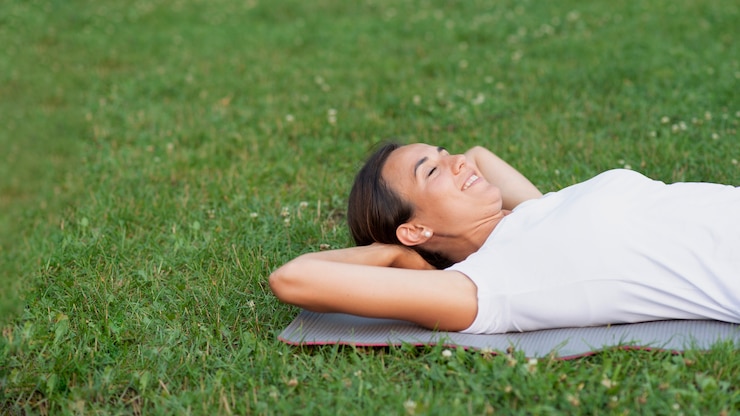 Photo gratuit femme souriante tir moyen couché sur l'herbe