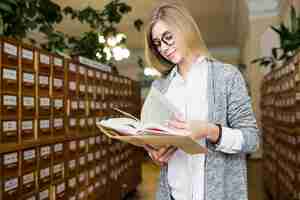 Photo gratuite femme souriante, tournant les pages du livre