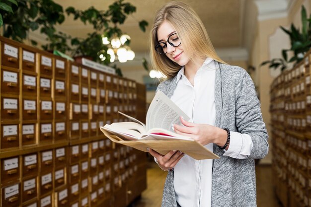 Femme souriante, tournant les pages du livre