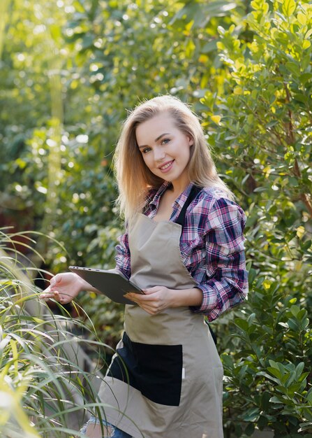 Femme souriante vérifiant l'état du feuillage