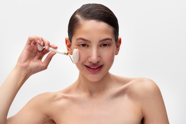 Femme souriante vue de face à l'aide d'un rouleau facial