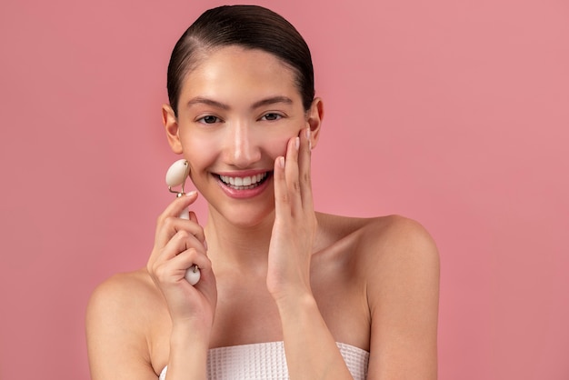 Femme souriante vue de face à l'aide d'un rouleau facial