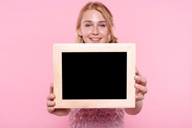 Femme souriante vue de face montrant des images
