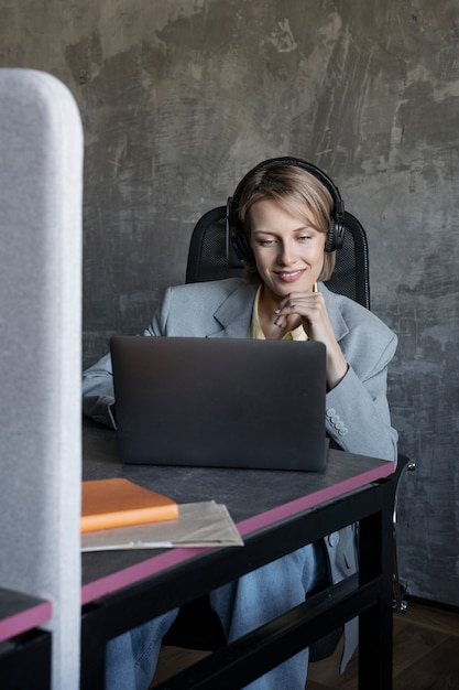 Femme souriante vue de face travaillant avec un ordinateur portable