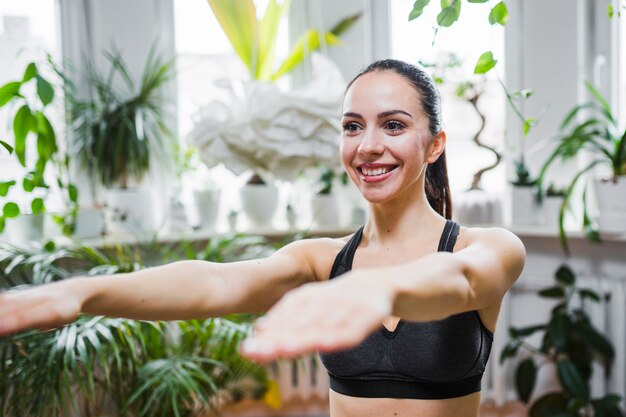 Femme en soutien-gorge de sport étirement des mains