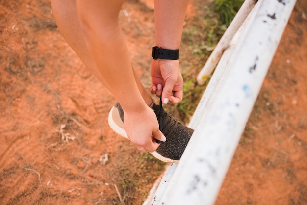 Photo gratuite femme sportive attachant des chaussures sur la piste du stade