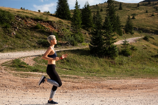 Femme sportive aux cheveux courts fonctionnant dans la nature