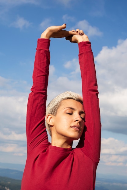 Femme sportive aux cheveux courts qui s'étend dans la nature