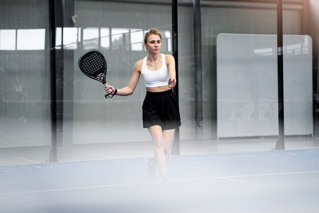 Femme sportive jouant au paddle-tennis vue latérale