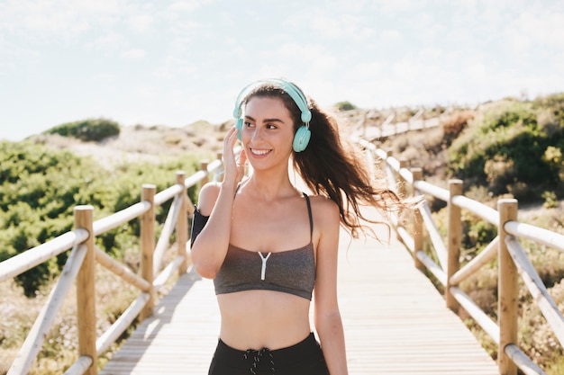 Photo gratuite femme sportive à la plage avec un casque