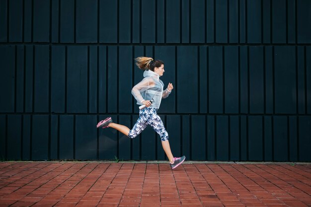 Femme sportive qui court en milieu urbain