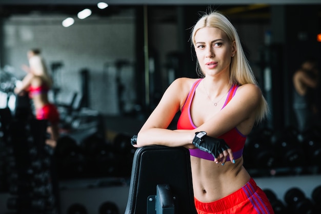 Femme sportive qui pose dans la salle de gym