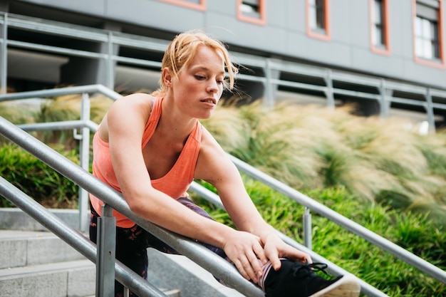 Femme sportive qui s&#39;étend en milieu urbain