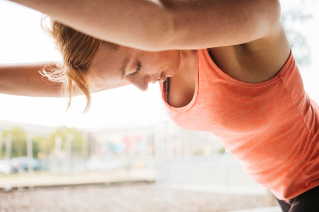 Femme sportive qui s'étend en milieu urbain