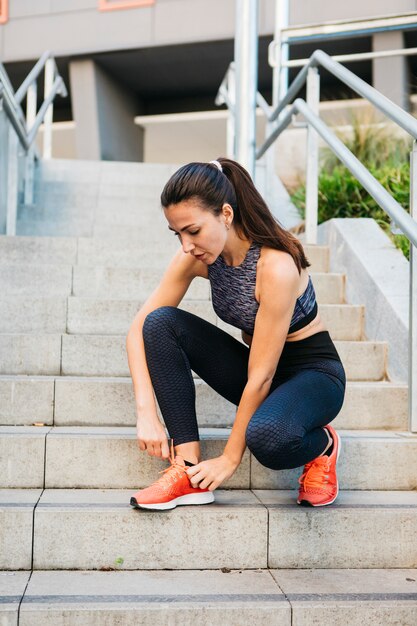 Femme sportive qui s&#39;étend en milieu urbain