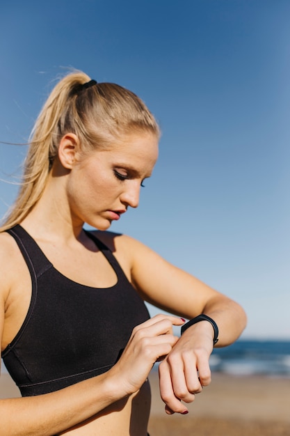 Photo gratuite femme sportive avec smartwatch à la plage