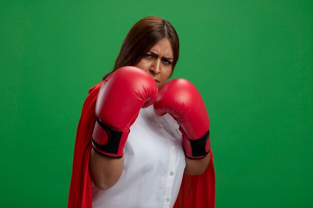 Femme De Super-héros D'âge Moyen Confiant Portant Des Gants De Boxe Debout Dans La Pose De Combat Isolé Sur Vert