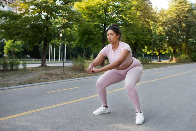 Femme en surpoids faisant de l'exercice à l'extérieur