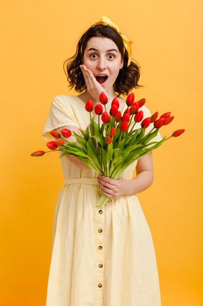 Femme surprise avec bouquet de fleurs