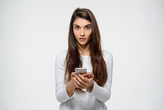 Femme surprise lire un message étrange sur le téléphone