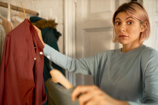 Une femme surprise reçoit des vêtements du centre de la machine à laver.