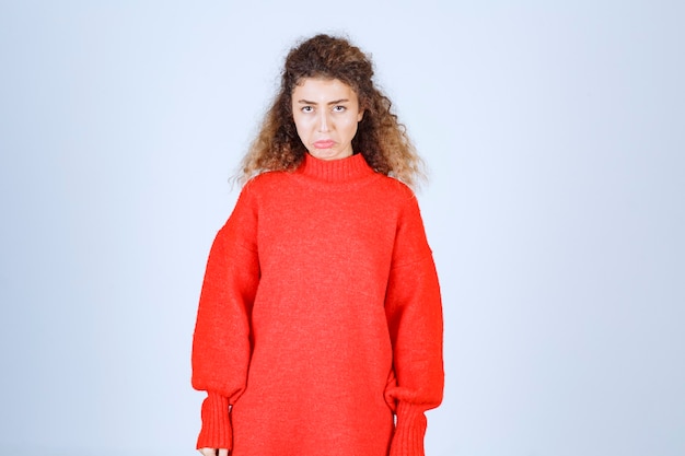 Photo gratuite la femme en sweat-shirt rouge a l'air confuse et réfléchie.