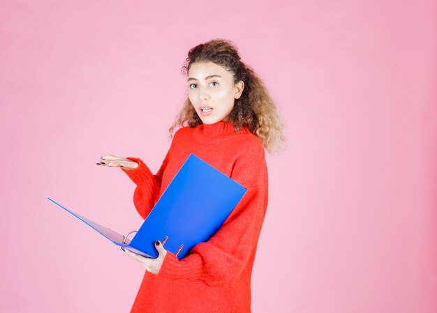 la femme en sweat-shirt rouge a l'air confuse et réfléchie.