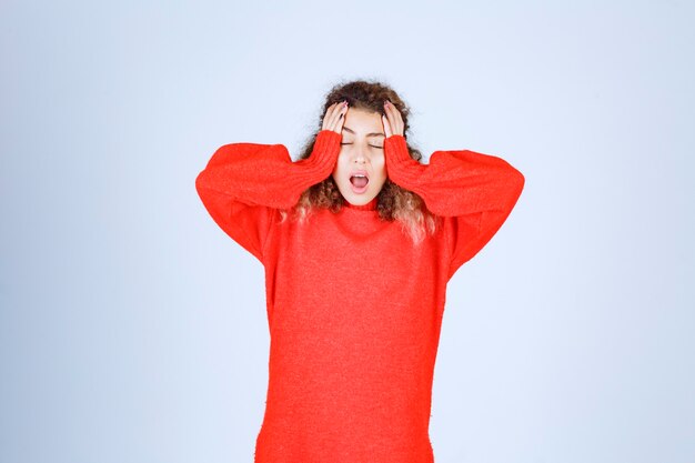 femme en sweat-shirt rouge a l'air endormie.