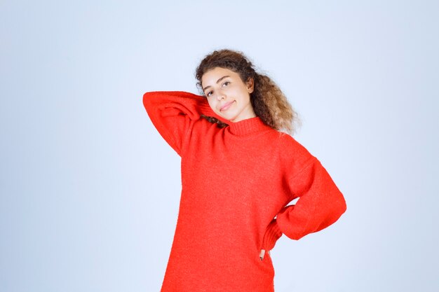 femme en sweat-shirt rouge donnant des poses souriantes et séduisantes.