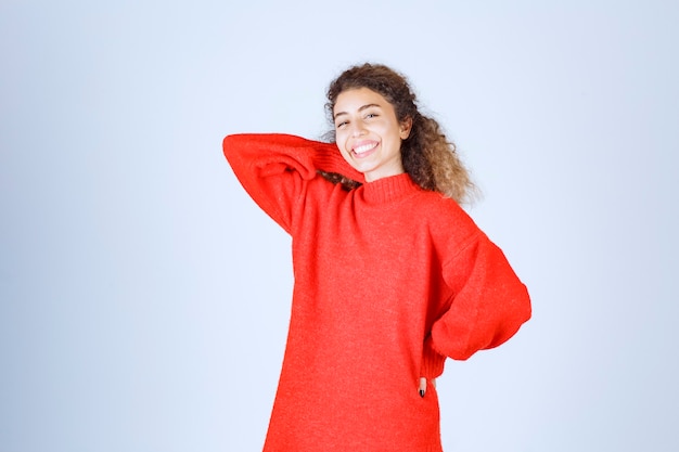 Photo gratuite femme en sweat-shirt rouge donnant des poses souriantes et séduisantes.