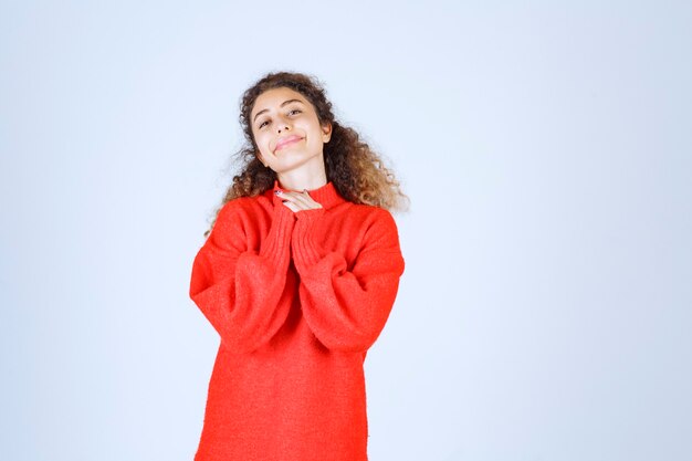 femme en sweat-shirt rouge donnant des poses souriantes et séduisantes.