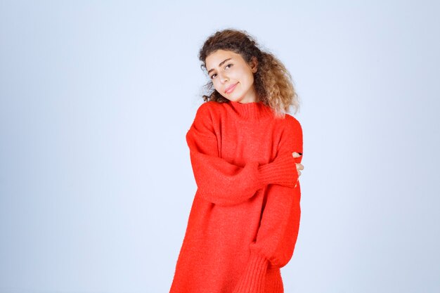 femme en sweat-shirt rouge donnant des poses souriantes et séduisantes.