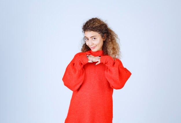 femme en sweat-shirt rouge donnant des poses souriantes et séduisantes.