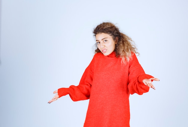 Photo gratuite femme en sweat-shirt rouge semble confuse et perdue.