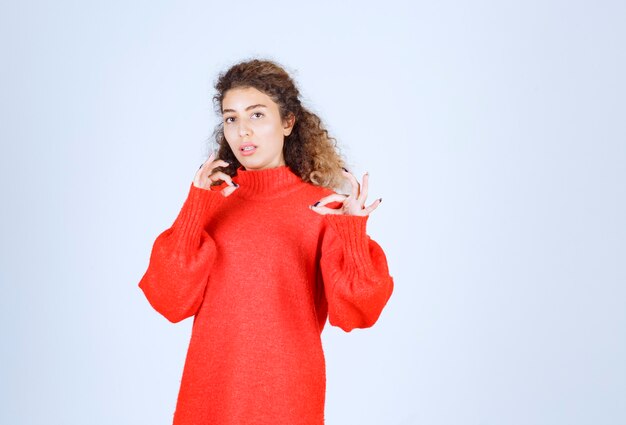 femme en sweat-shirt rouge semble confuse et perdue.