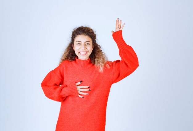 femme en sweat-shirt rouge signifiant son sourire.