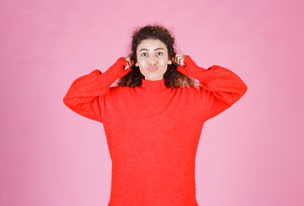 femme en sweat-shirt rouge signifiant son sourire.