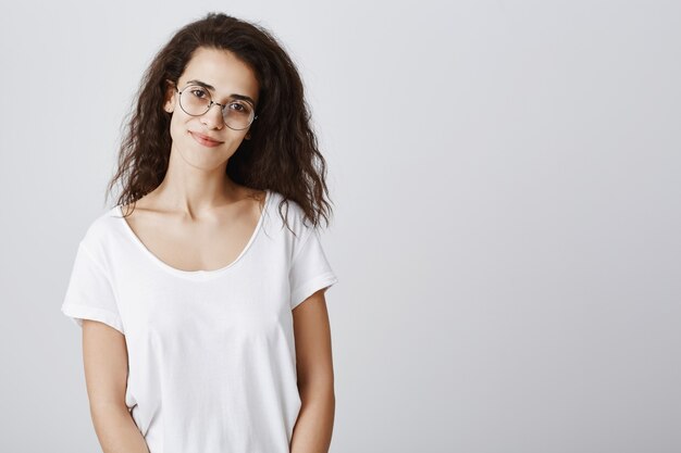 Femme sympathique souriante dans des verres à la recherche