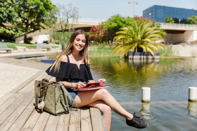 Femme avec tablette dans le parc avec lac