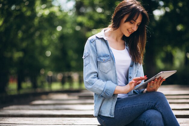 Femme avec tablette dans un parc