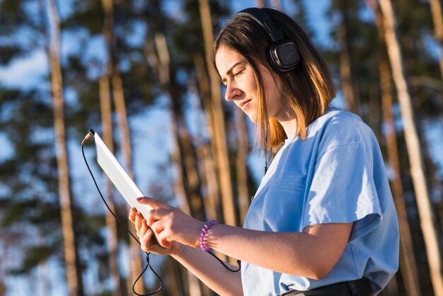 Femme avec tablette en écoutant de la musique