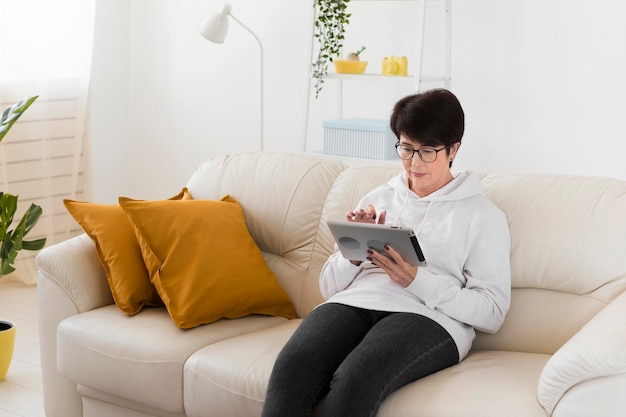 Femme sur tablette à la maison