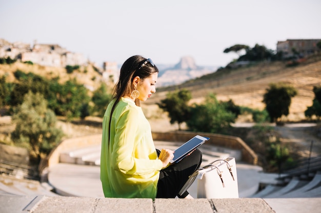 Femme avec tablette sur les marches