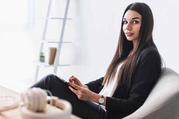 Femme avec tablette en regardant la caméra