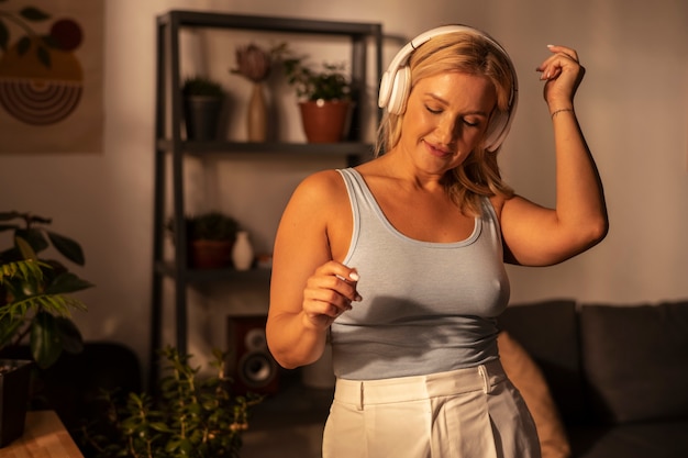 Photo gratuite une femme de taille moyenne avec des écouteurs à la maison.