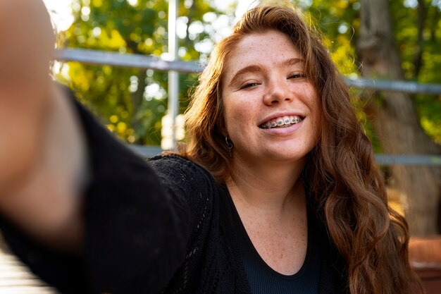 Une femme de taille moyenne se prend un selfie.