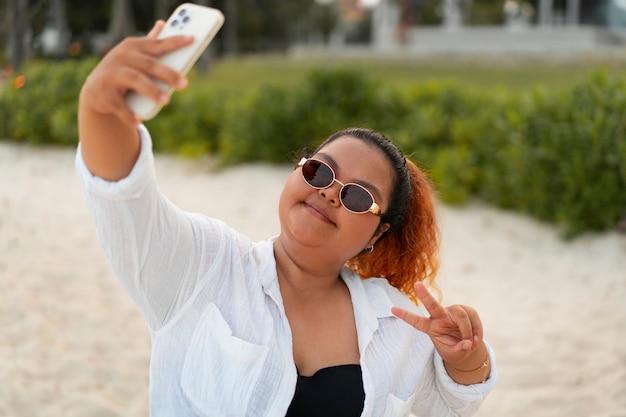 Une femme de taille moyenne se prend un selfie.