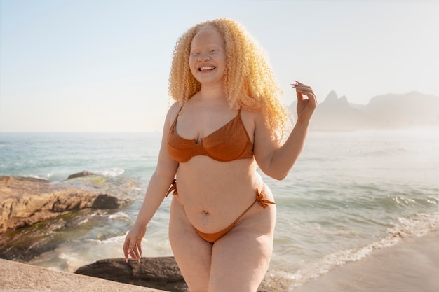 Une femme de taille plus posant au bord de la mer