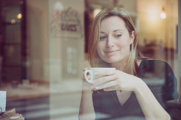 Femme avec une tasse de boisson chaude